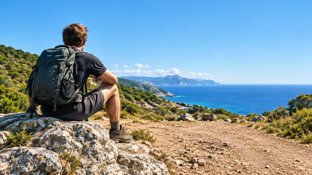 Backpacker resting on a cliff above the sea